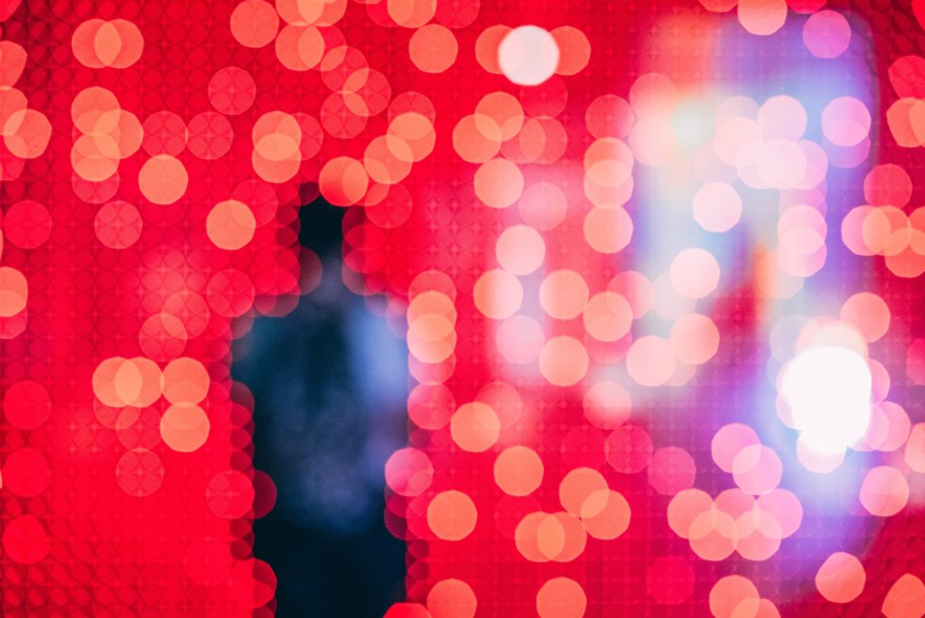 Photo par Guillaume Bourdages sur Unsplash. Une silhouette apparait au milieu de lumières floutées donnant l'impression d'une pixelisation aux pixels ronds. numérique
  